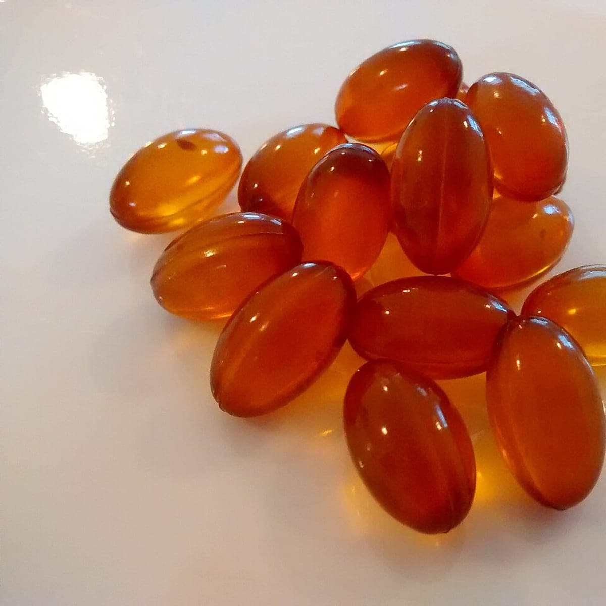 Sample image: a small pile of translucent amber softgel capsules on a white surface.