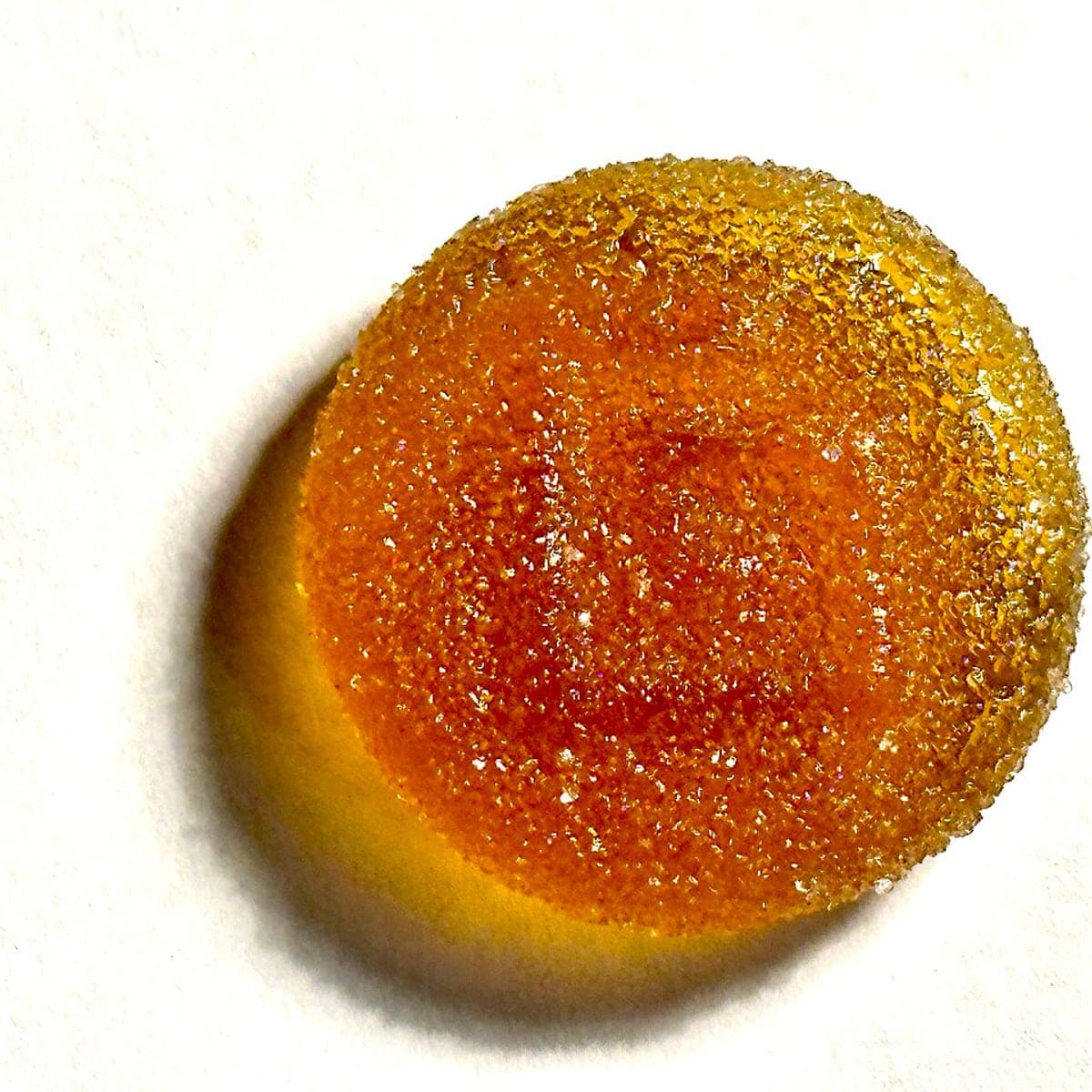Sample image: a single round amber gummy rolled in sugar, photographed on a white surface.